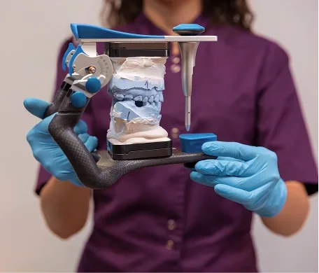 Dental technician holding a dental model